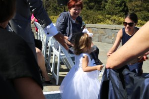 The darling flower girl walking down the aisle to her mom and grandma.